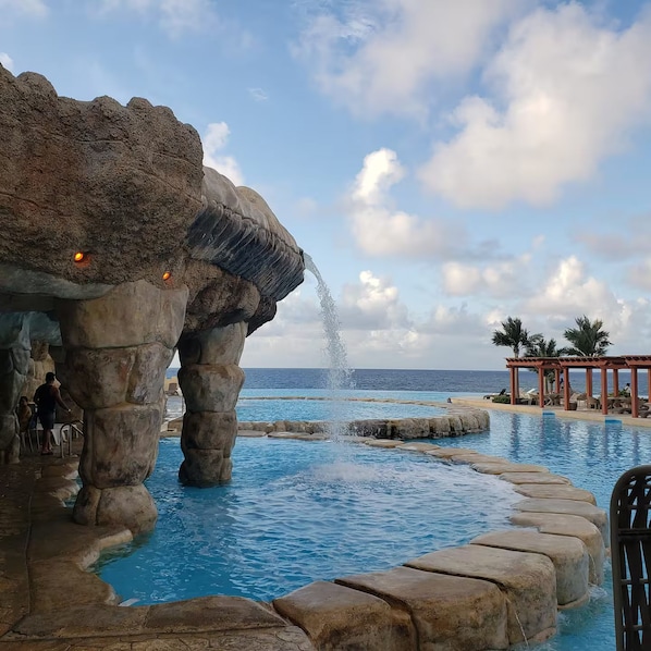Ein Pool mit Felsformation und Wasserspiel.