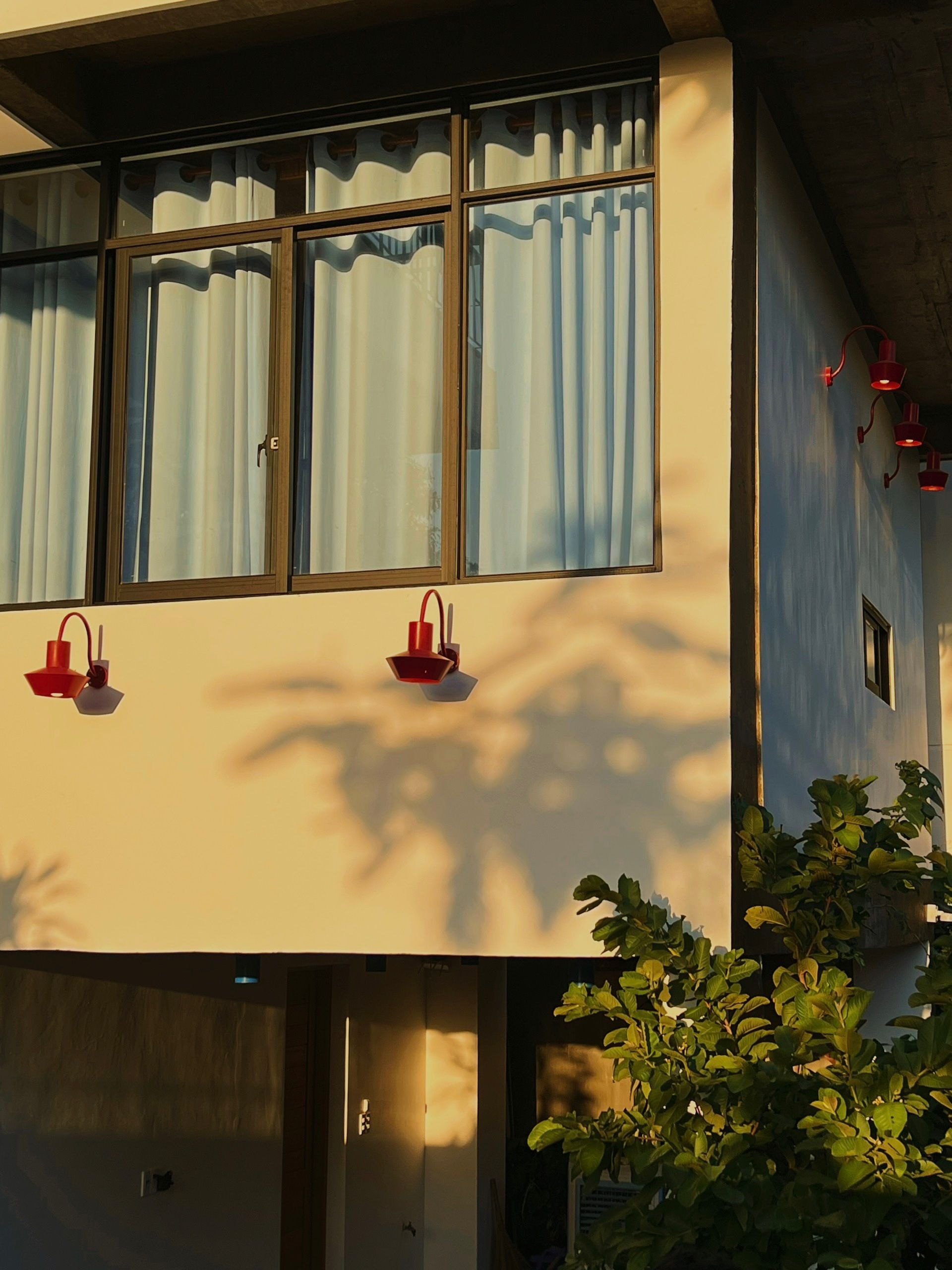 Un edificio con ventanas amplias, una puerta y un aplique de pared.