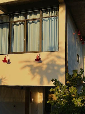 A building with large windows, a door, and a wall-mounted light fixture.