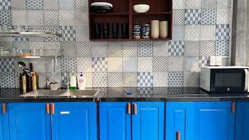 Una cucina con piastrelle decorative, un forno a microonde e mobili azzurri.