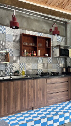 A kitchen with wooden cabinets, a tiled backsplash, and a checkered floor.