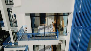 A modern hotel room with a balcony, a bed, and a window.