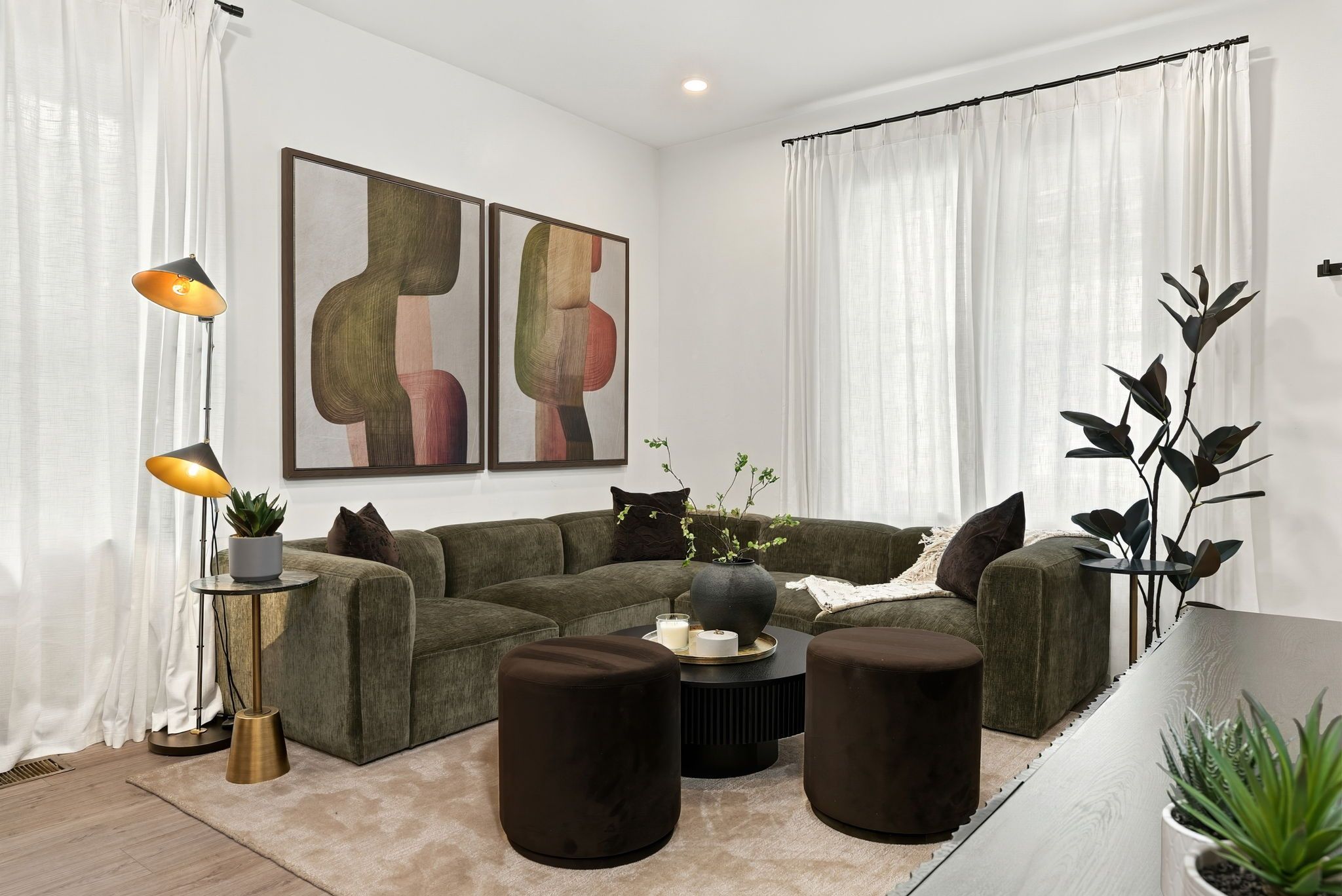 A modern living room with a sectional sofa, round coffee table, and two side tables.