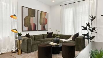 A modern living room with a sectional sofa, round coffee table, and two side tables.