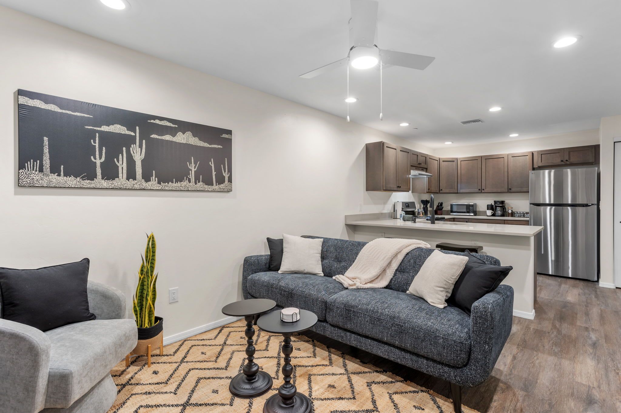 A modern living room with a grey sofa, a coffee table, and a large painting on the wall.