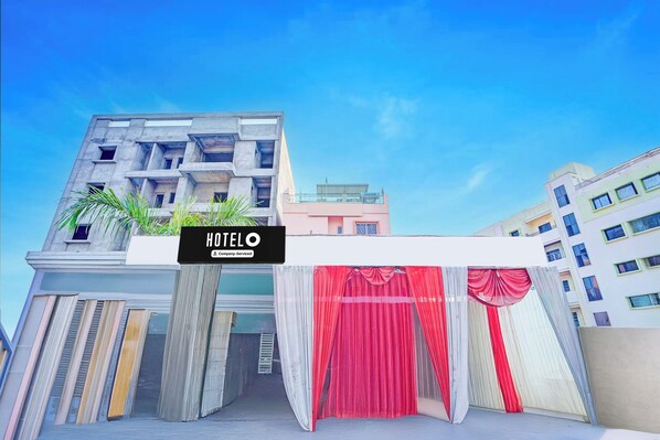 Entrada de hotel com uma placa que diz 'HOTELO Company Serviced'.