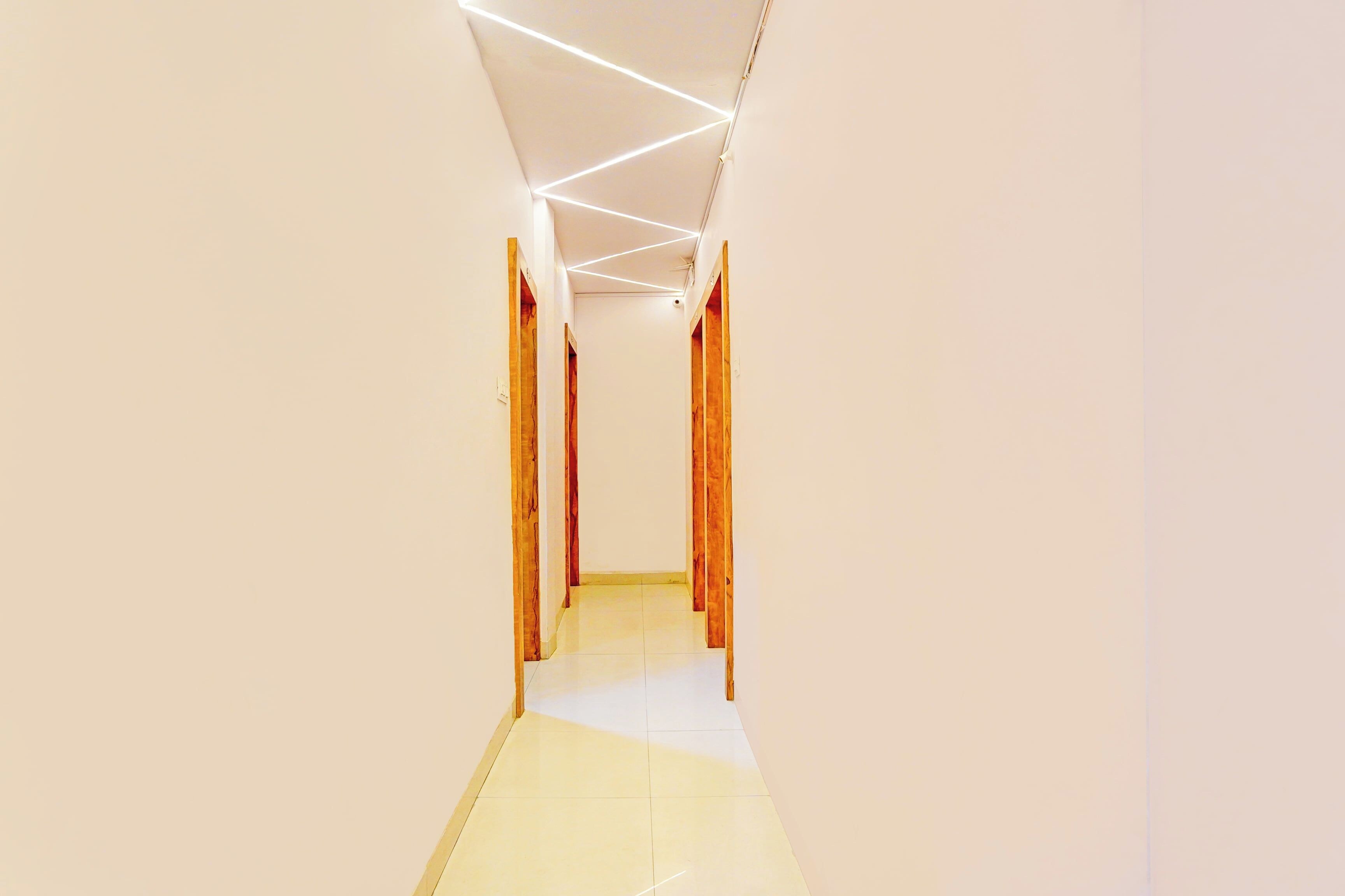 Un pasillo con puertas de madera y piso de baldosas.
