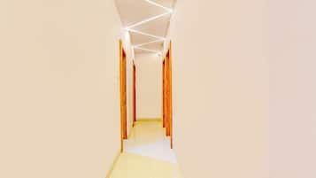 Un pasillo con puertas de madera y piso de baldosas.