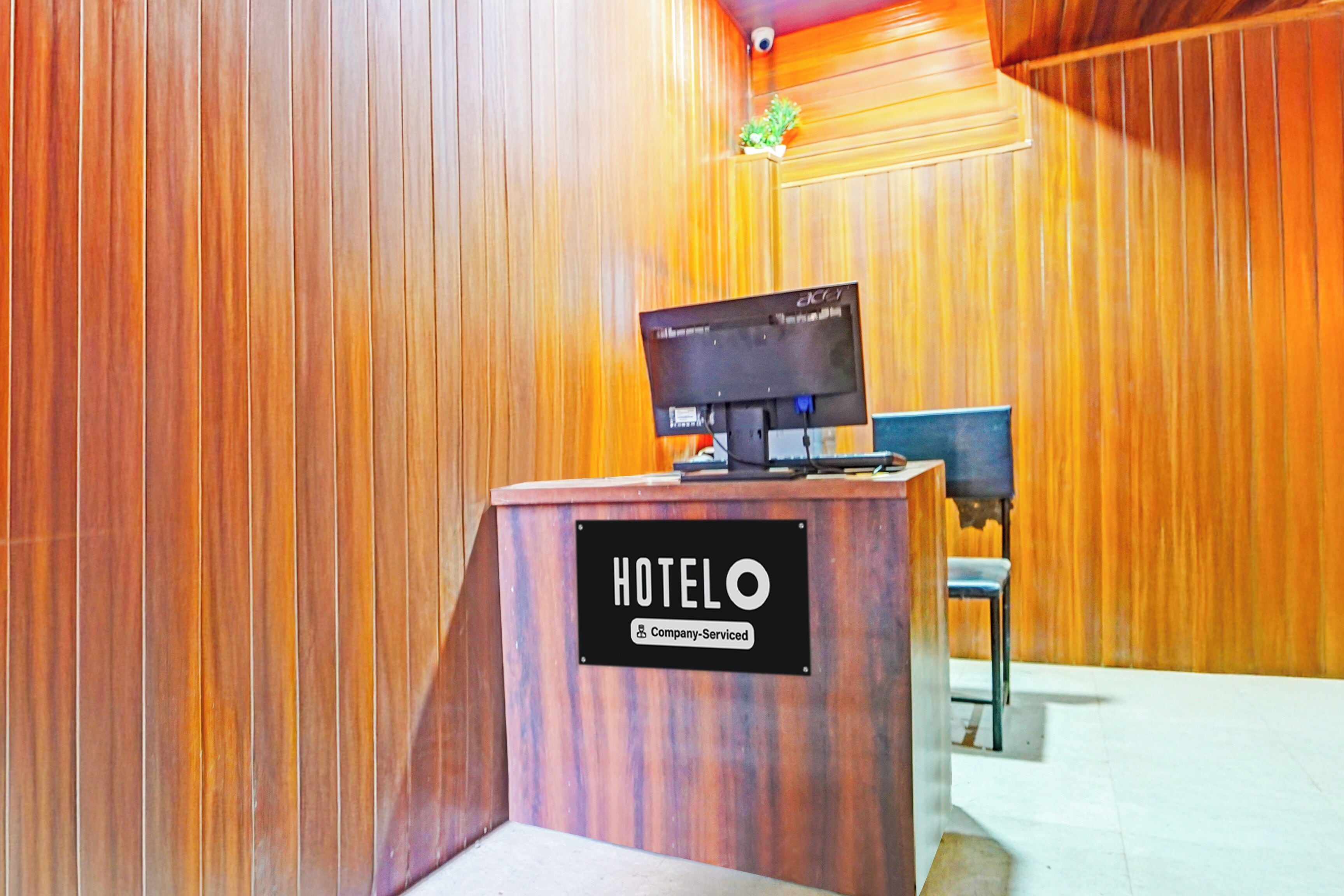 A hotel reception desk with a sign indicating it is company-serviced.