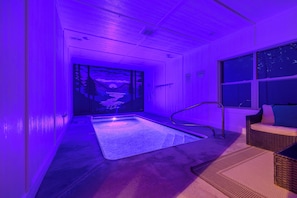 A room with a large window, a wooden door with a mural, and a small pool area. - 84° Indoor Pool, 75” TV, Hot Tub, Air Hockey, WIFI, Arcade, A+ Location (Pigeon Forge)