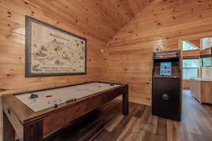 A room with a pool table, a framed map of Great Smoky Mountains National Park, and a slot machine. - 84° Indoor Pool, 75” TV, Hot Tub, Air Hockey, WIFI, Arcade, A+ Location (Pigeon Forge)