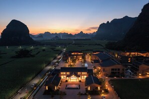 A hotel with a central courtyard, surrounded by buildings, set against a mountainous backdrop. - chongzuo longzhou guantang jiudian (Chongzuo)