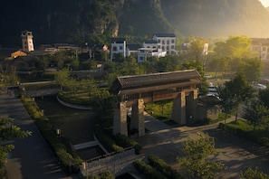 A traditional building with a tiled roof, stone pillars, and a stone pathway leading to it. - chongzuo longzhou guantang jiudian (Chongzuo)