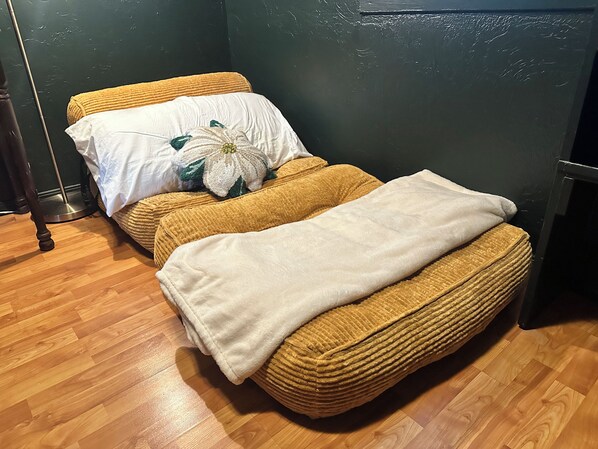 A room with a bed, a bedside table, and a floor lamp.