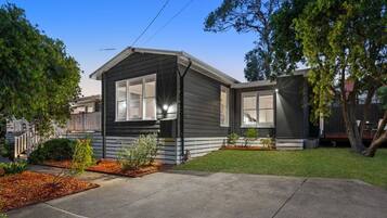 A single-story house with a front porch, a garage, and a well-maintained lawn.