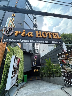 Entrada do Hotel Oria, com placa indicando o endereço e número de contato.