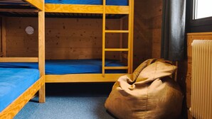 Een slaapkamer met een stapelbed, een slaapzak en een radiator.