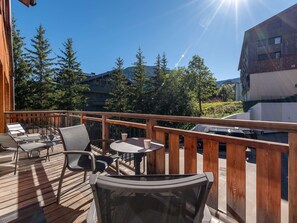 A wooden deck with outdoor seating, a pool, and a view of surrounding buildings and trees. - Chalet at the foot of the slopes, pets OK - 8 guests (Courchevel 1550)
