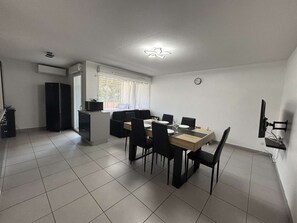 A compact living space with a dining area, kitchenette, and a small window. - Air-conditioned apartment - 4 guests (Argelès-sur-Mer)