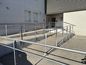 A set of outdoor stairs with metal railings leading to a building entrance. - Air-conditioned apartment - 4 guests (Argelès-sur-Mer)