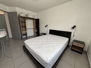 A bedroom with a bed, bedside tables, a desk, and a wardrobe. - Air-conditioned apartment - 4 guests (Argelès-sur-Mer)