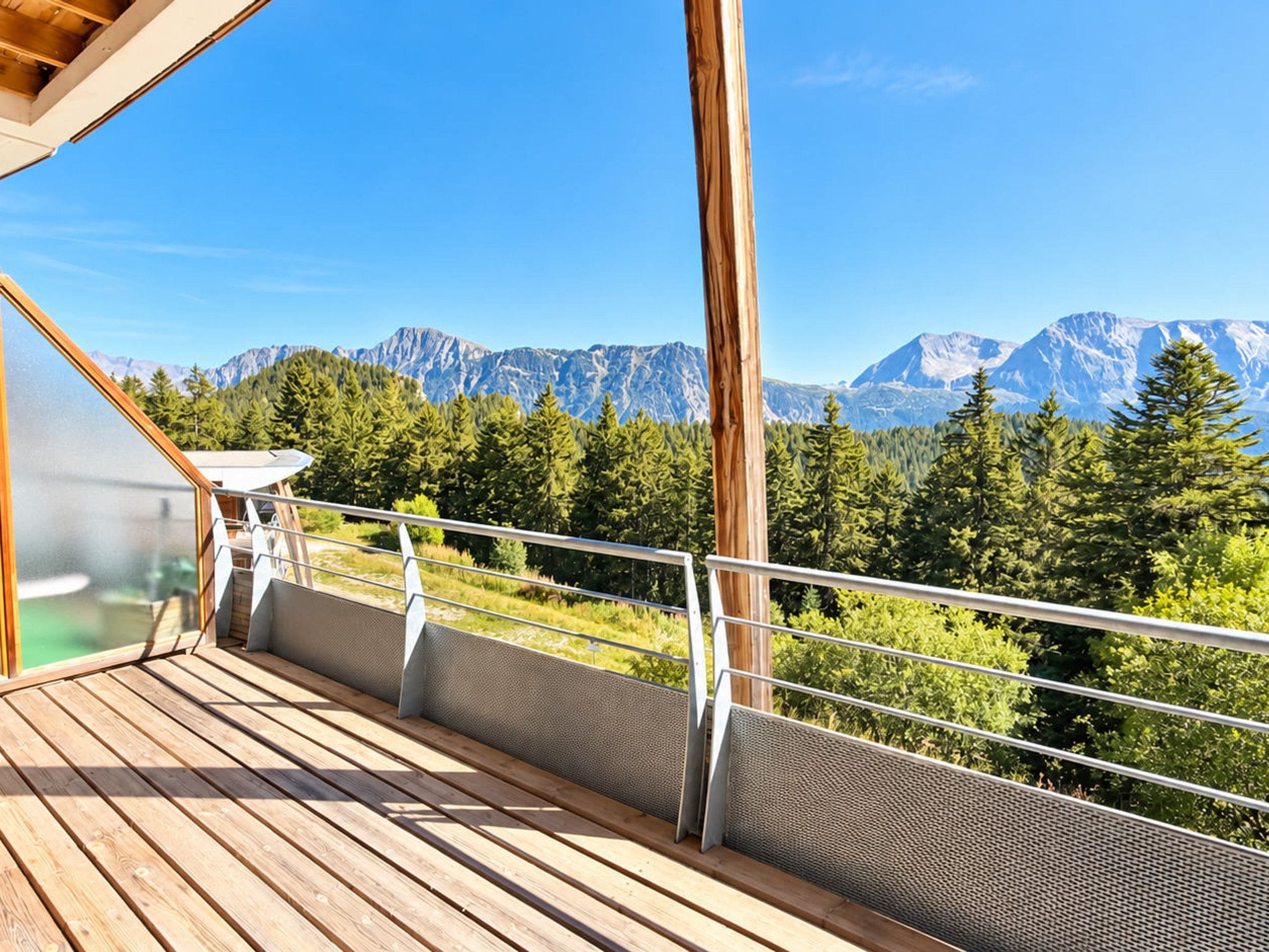 A wooden deck with a railing overlooking a mountainous landscape.