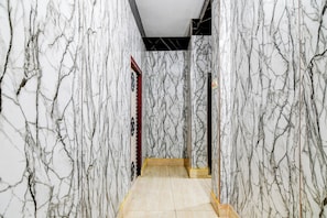 A hallway with marble walls and a tiled floor.