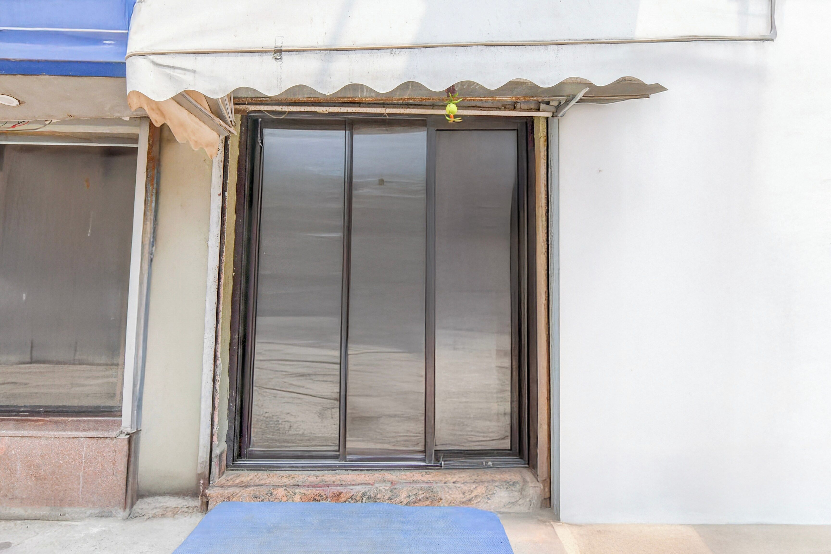 A building entrance with a metal door and a small step leading up to it.