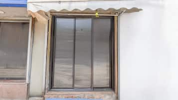 A building entrance with a metal door and a small step leading up to it.