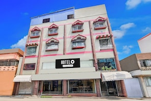 A multi-story hotel with a sign indicating it is company-serviced.