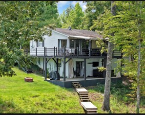 Een twee verdiepingen tellend huis met een overdekte veranda en een klein terras.