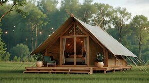 A wooden A-frame cabin with a covered porch, large windows, and potted plants.