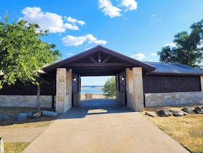 A stone building with a covered entrance and a view of a body of water.