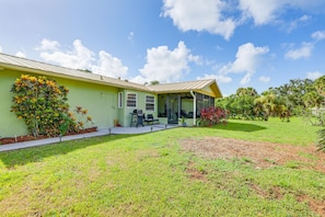A single-story house with a covered porch, a lawn, and a variety of plants. - 2BR Pet-Friendly – Walk or Bike to Manasota Beach (Englewood)