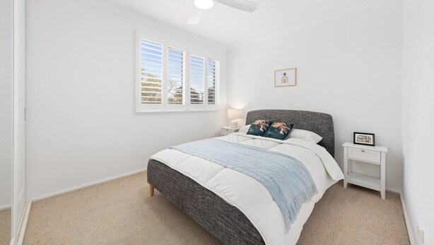 A bedroom with a bed, a nightstand, a ceiling fan, and a window with blinds. - Spacious Family Home with Multiple Living Areas (Baulkham Hills)