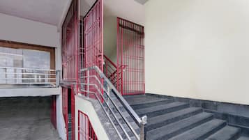 A staircase with red railings leading to an upper floor.