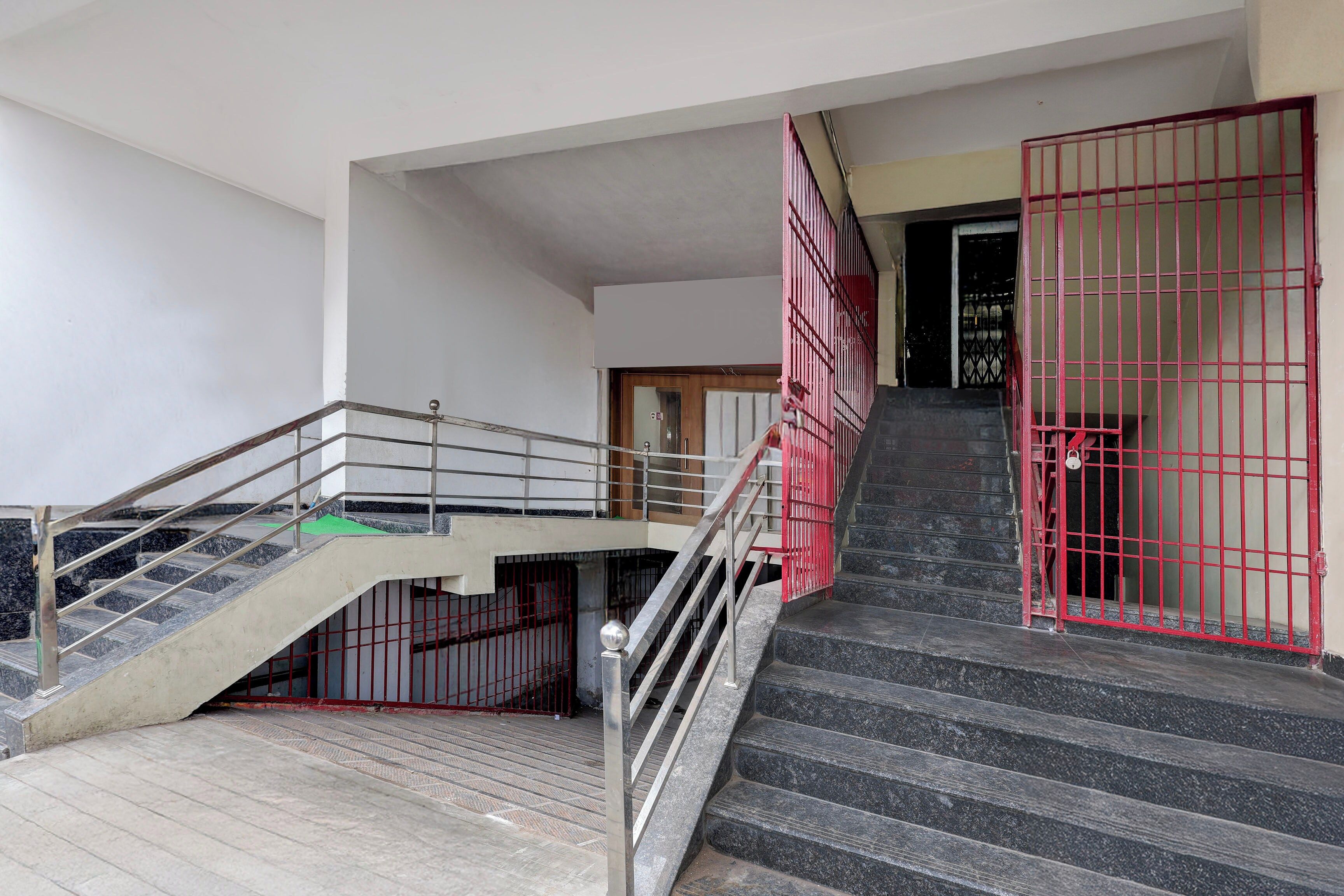 A staircase with metal railings and a red gate at the top.