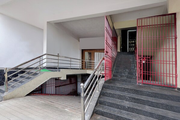 A staircase with metal railings and a red gate at the top.