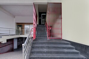 A staircase with metal railings and a red gate at the top.