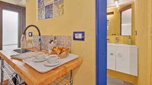 A kitchen with a wooden countertop, a sink, and a wall-mounted TV. - Borghetto La Borra & Borretta, Serramazzoni, Italy (Serramazzoni)