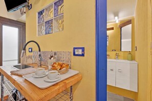 Een keuken met een houten aanrecht, een spoelbak en een aan de muur gemonteerde televisie.