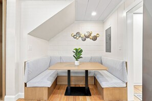 A corner seating area with a wooden table and light grey cushions. - Elvi's Beach B | 3BR Coastal Getaway (North Myrtle Beach)