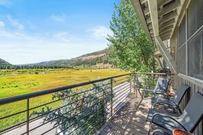 A balcony with a view of a green field and hills. - New! Ski Days + Sunset Après | 3BR Mountain Retreat | Walk to Ski + Garage (Telluride)