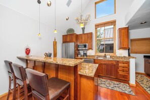 A modern kitchen with wooden cabinets, granite countertops, and stainless steel appliances. - New! Ski Days + Sunset Après | 3BR Mountain Retreat | Walk to Ski + Garage (Telluride)