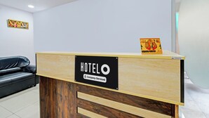 Balcão de recepção de hotel com aviso indicando serviço da empresa.