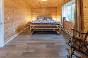 A wooden interior with a bed, a bench, and a window. - Gorgeous 2-bedroom cabin in charming Big Lake perfect for relaxing getaway (Big Lake)