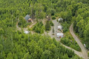 A remote cabin surrounded by dense forest, with a dirt road leading to it. - Gorgeous 2-bedroom cabin in charming Big Lake perfect for relaxing getaway (Big Lake)