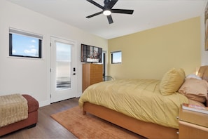 A bedroom with a bed, a ceiling fan, a dresser, and a window. - Newly Built Modern Townhome - Pet Friendly, Private Hot Tub, Walk to Restaurants (Fraser)