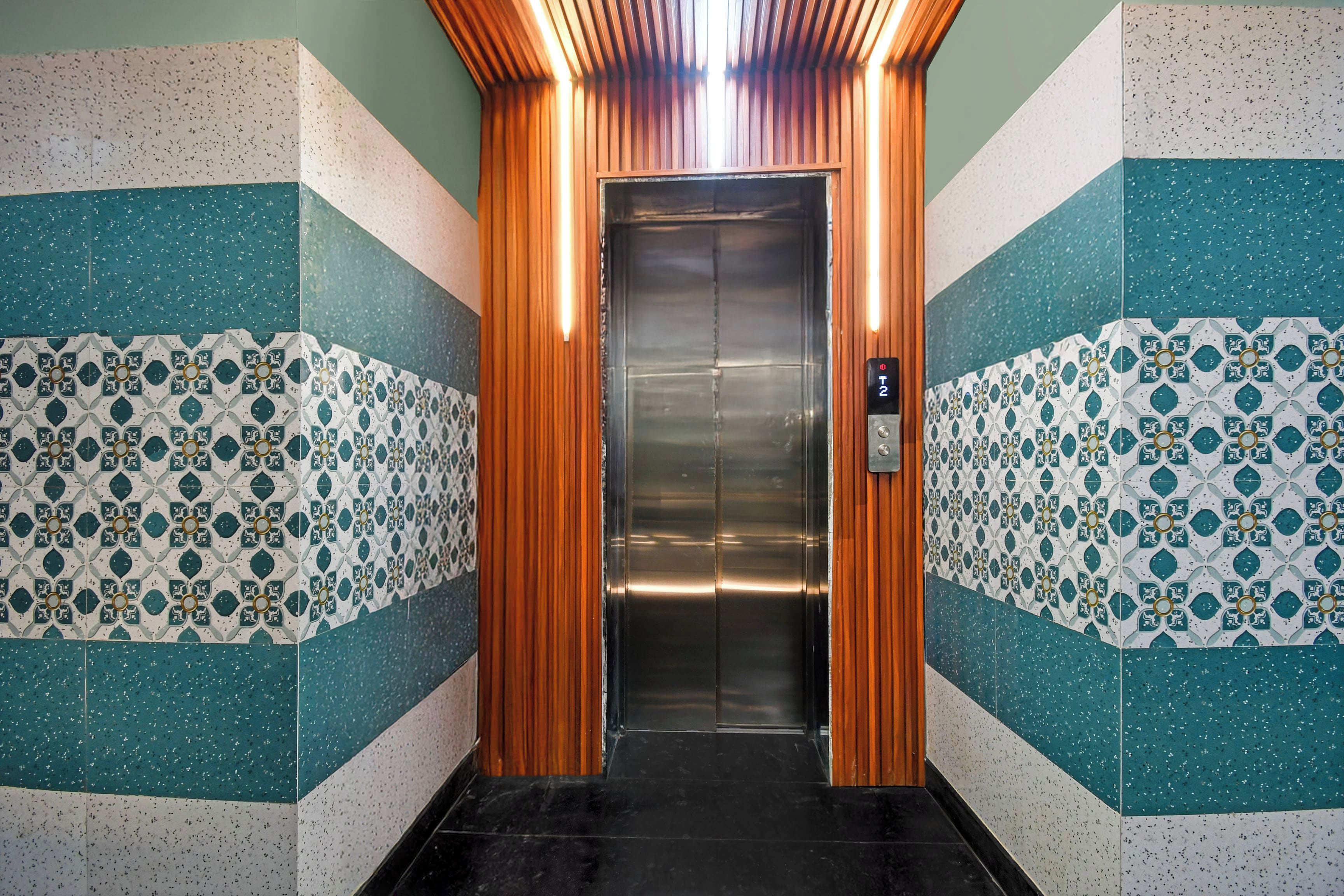 An elevator with a metallic interior and a control panel displaying floor numbers.