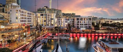 A waterfront hotel with multiple floors, a prominent tower, and a marina with boats.